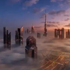Wieżowce w chmurach, gdzie jest największy budynek na świecie. Wschód słońca nad Dubajem.