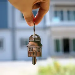 Klucz do domu w kształcie domu, wiszący na palcu. Zastanawiasz się, ile kosztuje wynajem mieszkania w Niemczech?