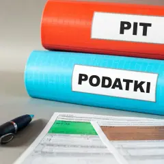 Dwa segregator, jeden z napisem "PIT", drugi "PODATKI", leżą obok formularzy podatkowych i długopisu. Właściciel mieszkania musi wiedzieć, jakie podatki płaci.