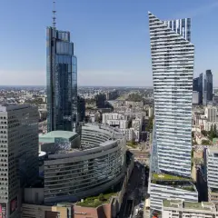 Warszawskie wieżowce, w tym najwyższy budynek w Warszawie, na tle błękitnego nieba.