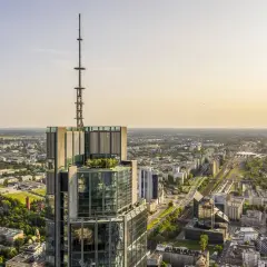 Widok z lotu ptaka na wieżowiec w Warszawie z anteną na szczycie. Zastanawiasz się, ile pięter ma Warsaw Tower? To imponująca budowla.