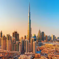 Panorama Dubaju z Burj Khalifa, zaprojektowaną przez Adriana Smitha, w złotym świetle zachodzącego słońca.
