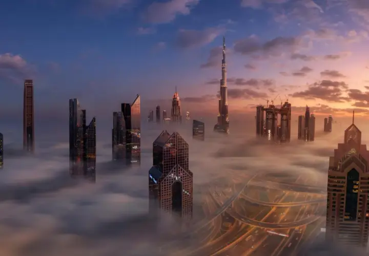 Wieżowce w chmurach, gdzie jest największy budynek na świecie. Wschód słońca nad Dubajem.