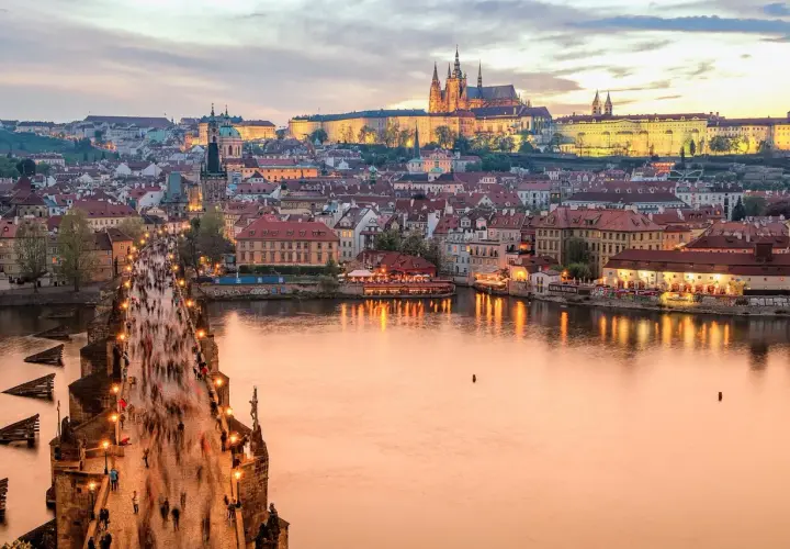 Zachód słońca nad Pragą, tłumy na Moście Karola. Zastanawiasz się, ile kosztuje życie w Czechach?