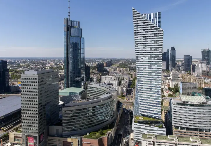 Warszawskie wieżowce, w tym najwyższy budynek w Warszawie, na tle błękitnego nieba.
