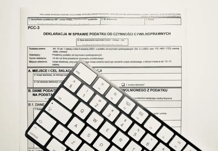 Formularz PCC-3 i klawiatura. Wpisz "podatek od nieruchomości" w tytule przelewu, aby poprawnie opłacić należność.