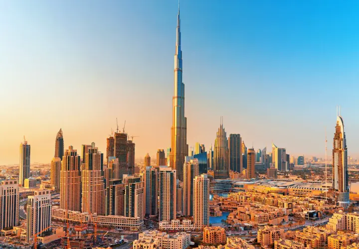 Panorama Dubaju z Burj Khalifa, zaprojektowaną przez Adriana Smitha, w złotym świetle zachodzącego słońca.