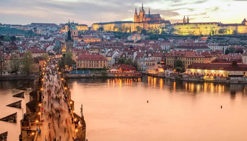 Zachód słońca nad Pragą, tłumy na Moście Karola. Zastanawiasz się, ile kosztuje życie w Czechach?