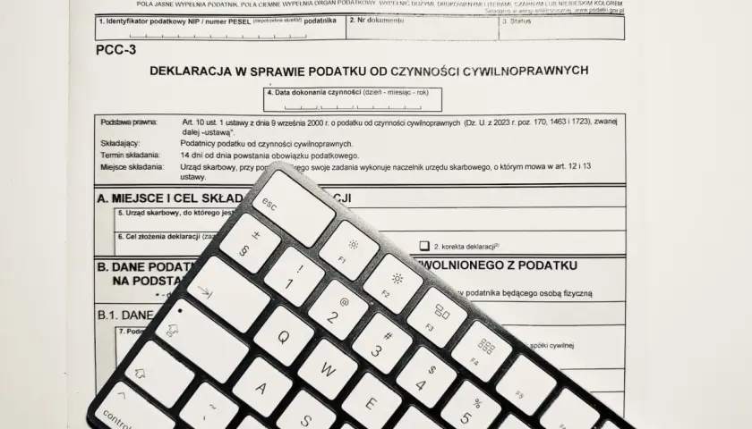 Formularz PCC-3 i klawiatura. Wpisz "podatek od nieruchomości" w tytule przelewu, aby poprawnie opłacić należność.