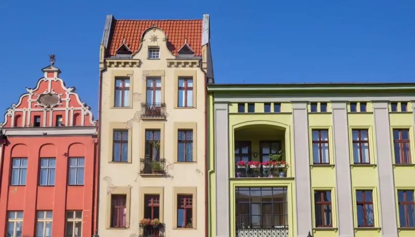 Kolorowe kamienice, jak ustalić rok budowy bloku? Zwróć uwagę na detale architektoniczne, zdobienia i styl okien.