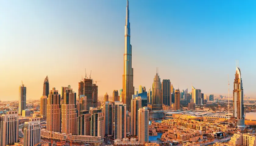 Panorama Dubaju z Burj Khalifa, zaprojektowaną przez Adriana Smitha, w złotym świetle zachodzącego słońca.