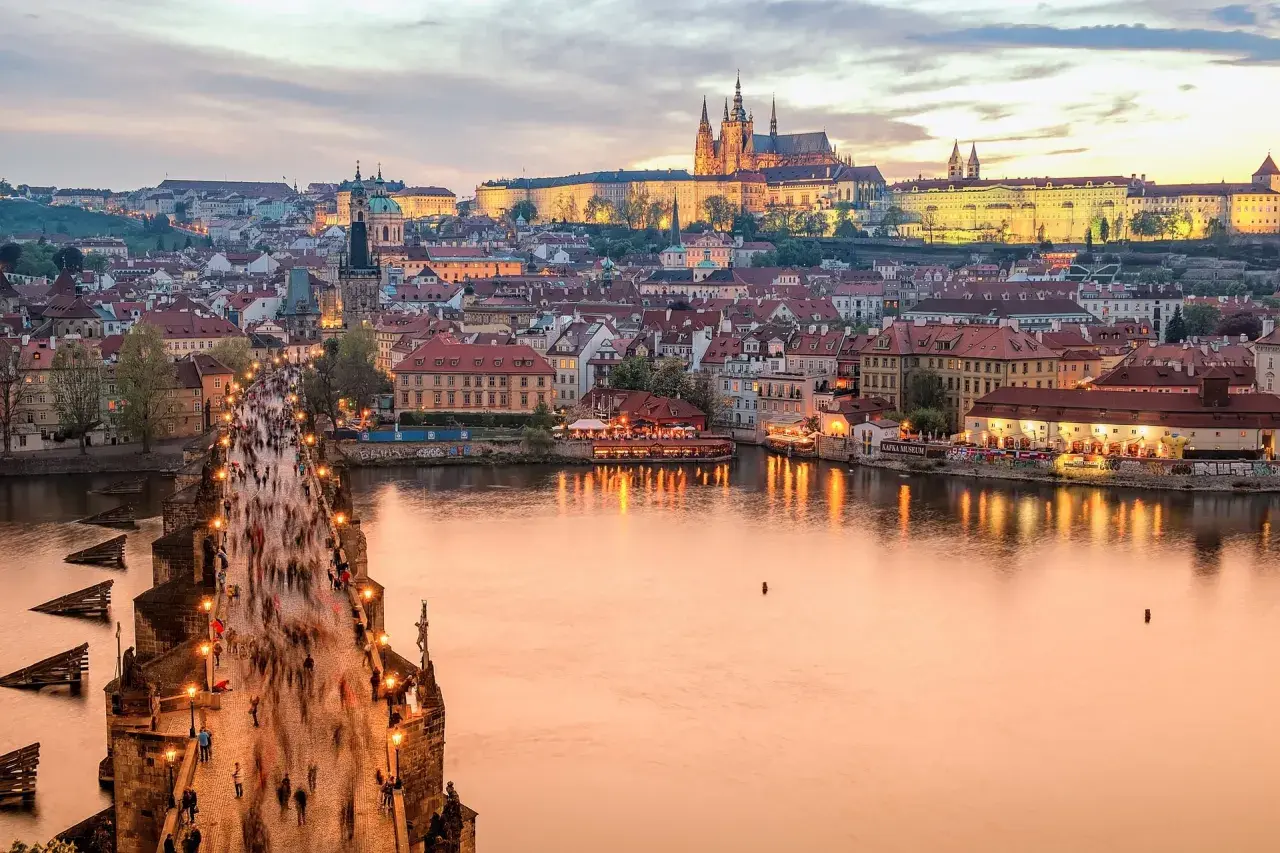 Zachód słońca nad Pragą, tłumy na Moście Karola. Zastanawiasz się, ile kosztuje życie w Czechach?