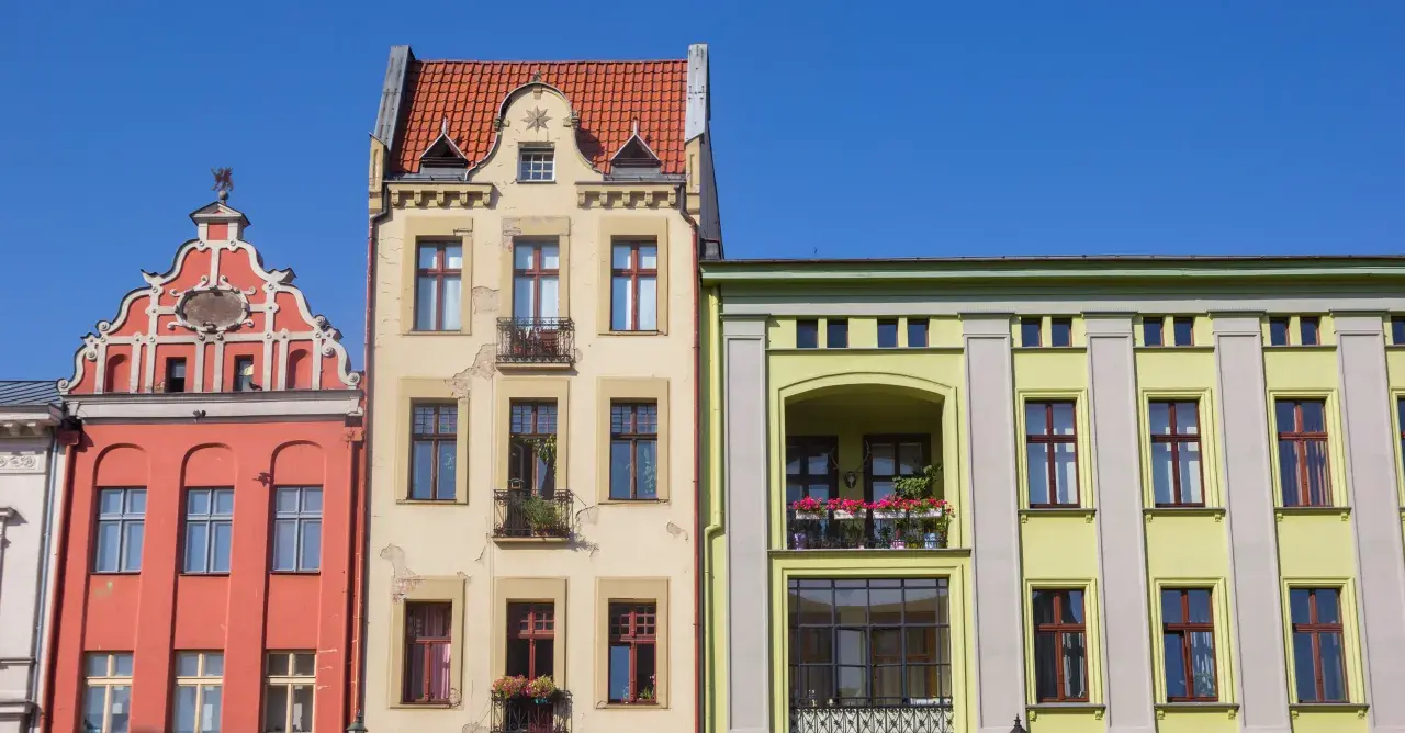 Kolorowe kamienice, jak ustalić rok budowy bloku? Zwróć uwagę na detale architektoniczne, zdobienia i styl okien.