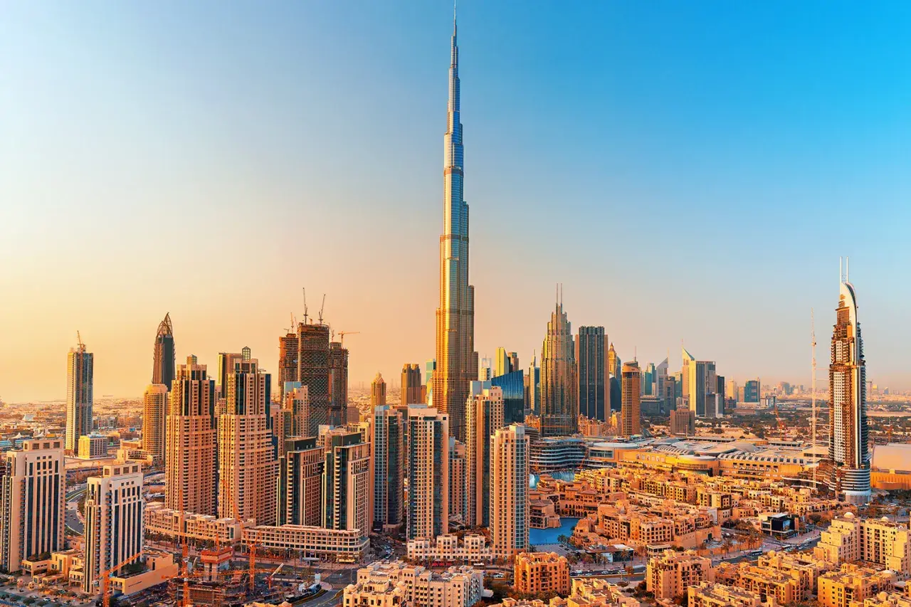Panorama Dubaju z Burj Khalifa, zaprojektowaną przez Adriana Smitha, w złotym świetle zachodzącego słońca.