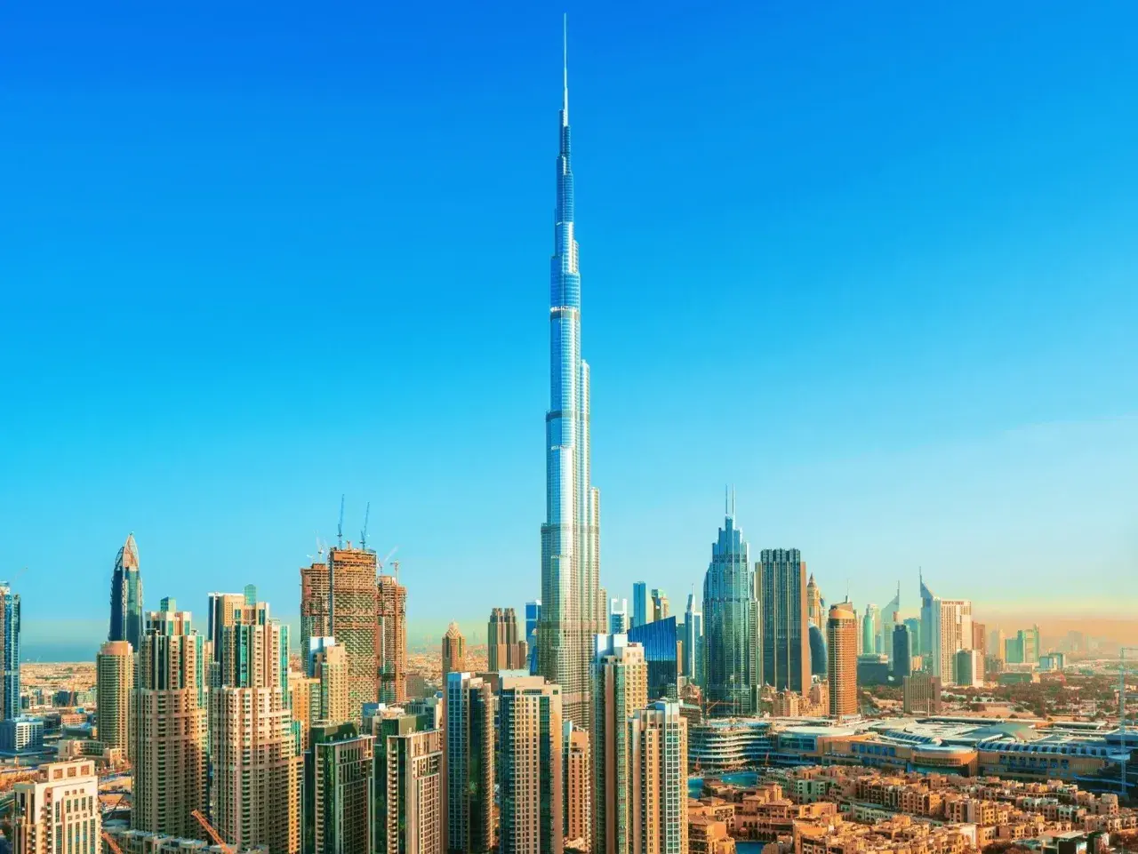 Burj Khalifa, najwyższy budynek świata, ma 163 piętra. Widać go na tle błękitnego nieba nad Dubajem.