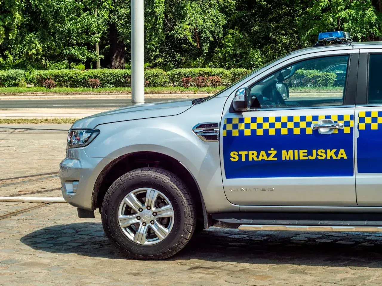 Samochód Straży Miejskiej z napisem "STRAŻ MIEJSKA" na drzwiach. Czy straż miejska może wystawić mandat za złe parkowanie? Tak, może.