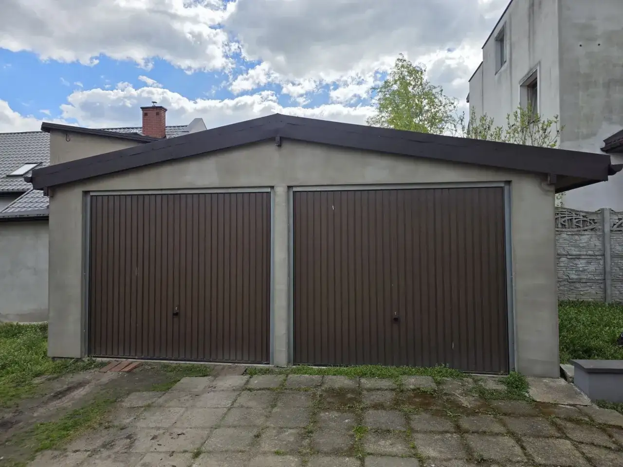 Dwustanowiskowy garaż murowany z brązowymi bramami. Zastanawiasz się, ile kosztuje wynajęcie garażu murowanego?