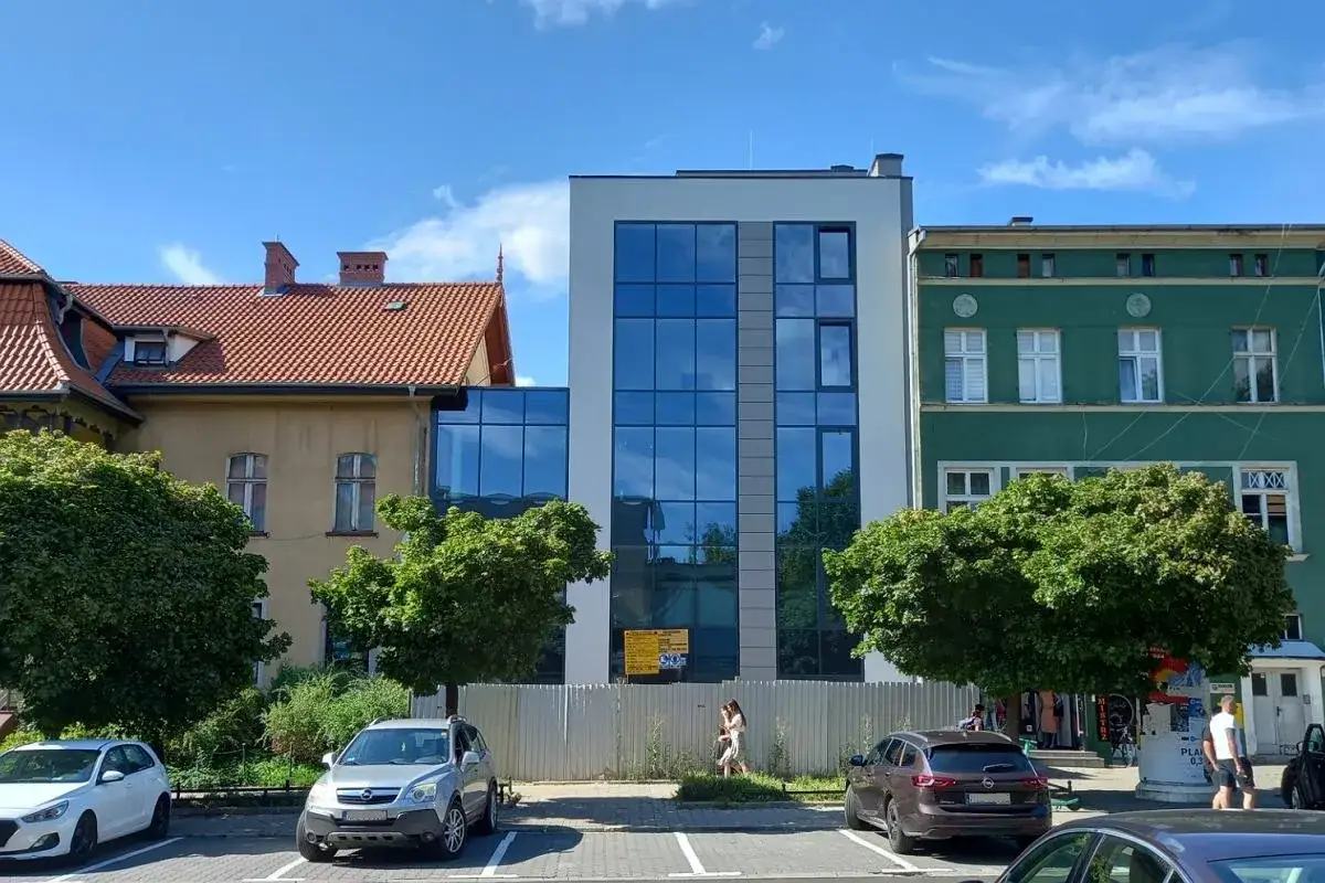 Nowoczesny, szklany budynek sąsiaduje ze starszymi kamienicami. Co to za budynek?