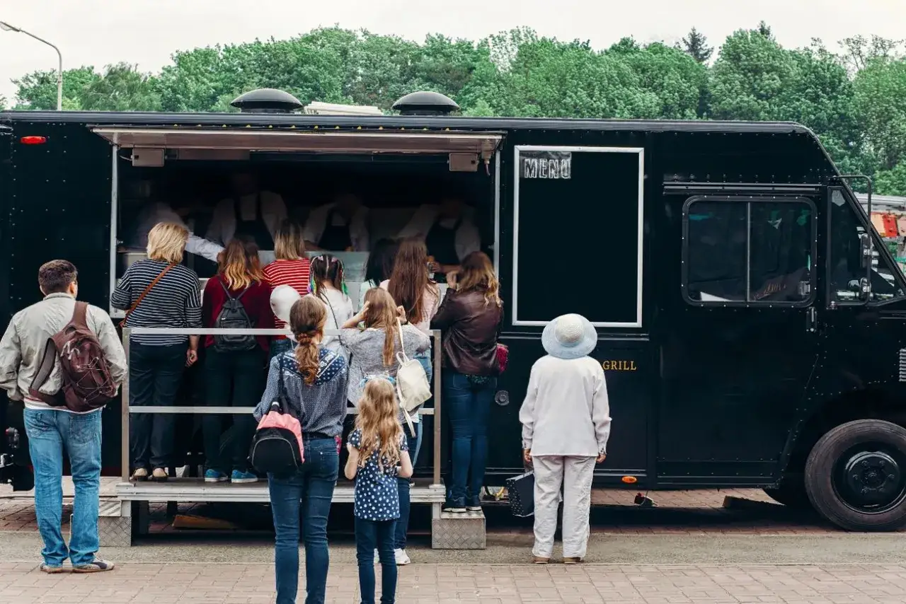 Kolejka do food trucka. Ludzie czekają, by dowiedzieć się, jak zamówić food trucka i co jest w menu.
