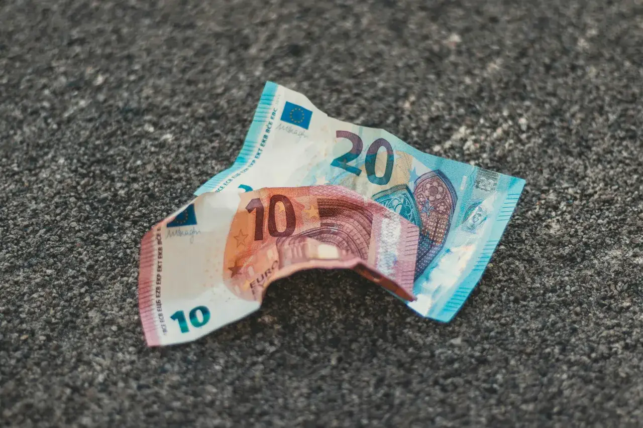 Dwa banknoty euro, 10 i 20, leżą na szarej, kamienistej powierzchni. Czy życie na Cyprze jest drogie? Te pieniądze mogą nie wystarczyć.