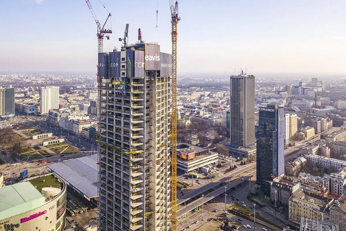 Budowa Varso Tower w Warszawie. Widać konstrukcję wieżowca, dźwigi i panoramę miasta.