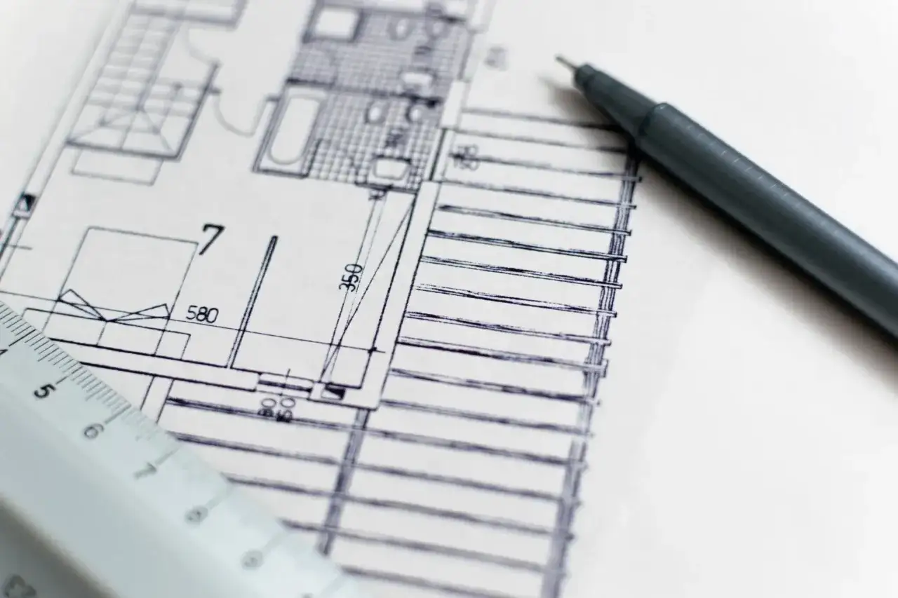 Plan architektoniczny, linijka i długopis. Zastanawiasz się, ile kosztuje ekspertyza budowlana?