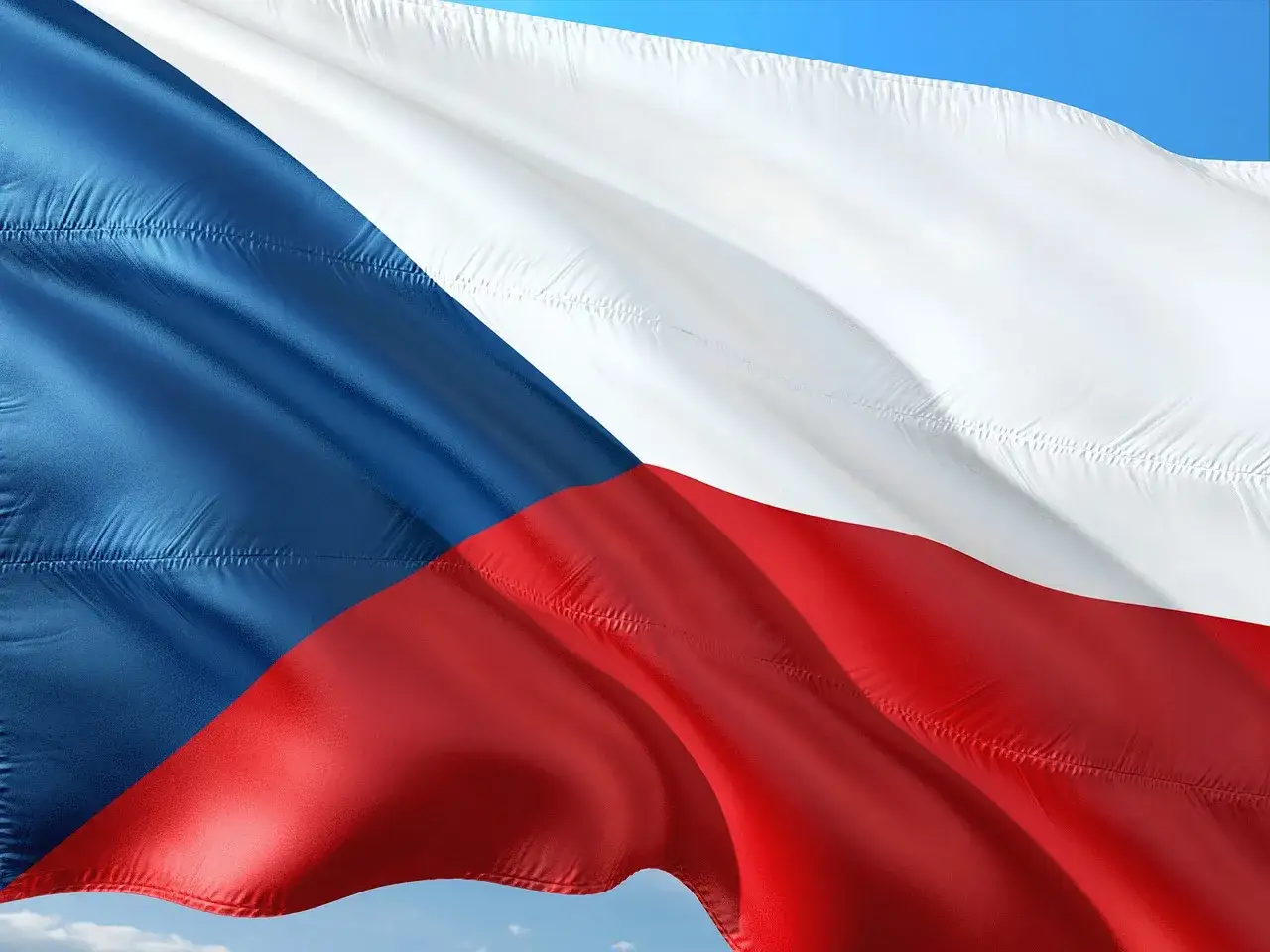Flaga Czech falująca na wietrze. Zastanawiasz się, ile kosztuje życie w Czechach?